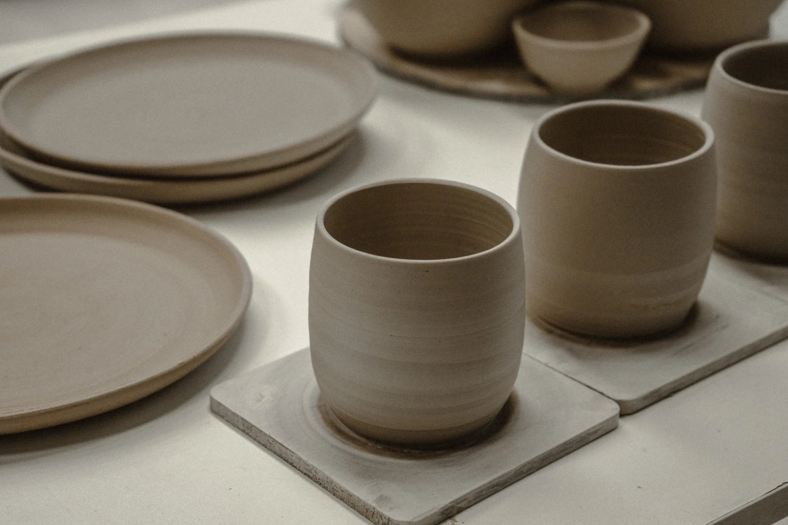 A grouping of cream stoneware vessels and plates