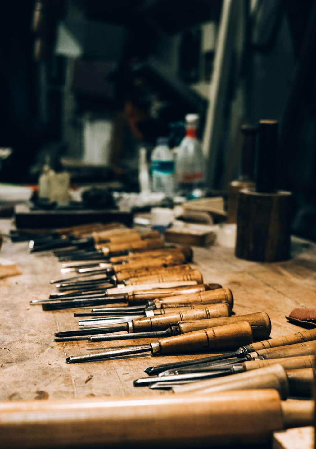 Hand-carving chisels lined up on a workbench